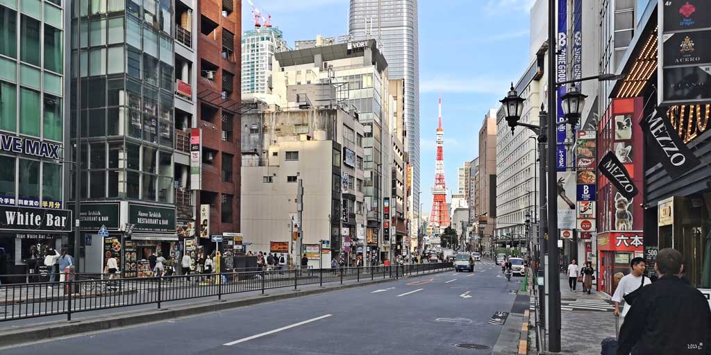 Normales Straßenleben mit Blick auf den Tokyo Tower